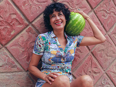 founder of Sno con Amor Lauda Flores holding a watermelon, one of the many natural ingredients she uses to create her artisanal Mexican paletas and snow cones